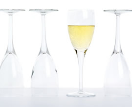 Image of Four Glasses. Three turned upside down and one full with champange